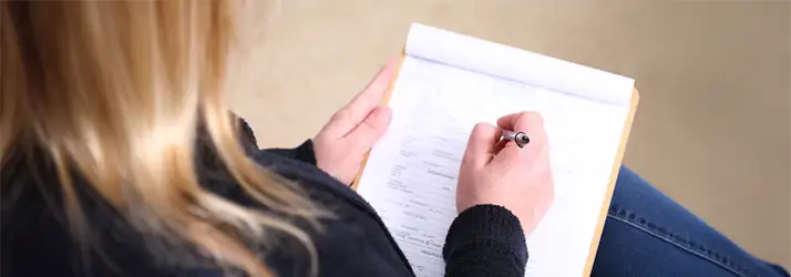Chiropractic Brenham TX Your First Appointment A women filling out paperwork before a doctor appointment
