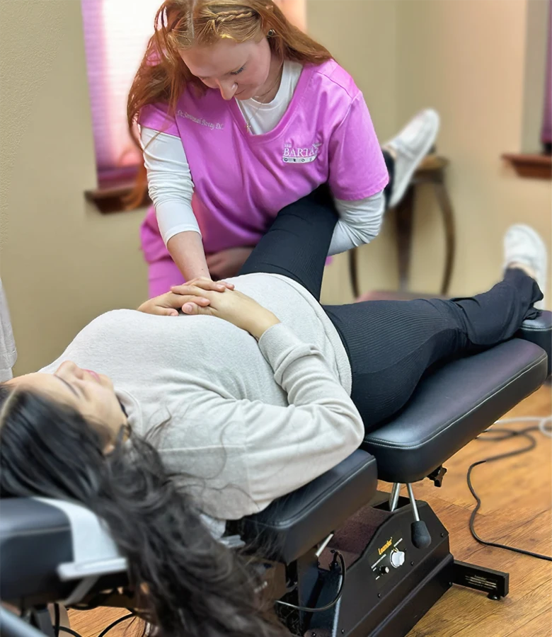 Savannah Bartay Adjusting Patient Grabbing Leg